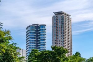 Two modern high-rise residential buildings under a clear blue sky.
